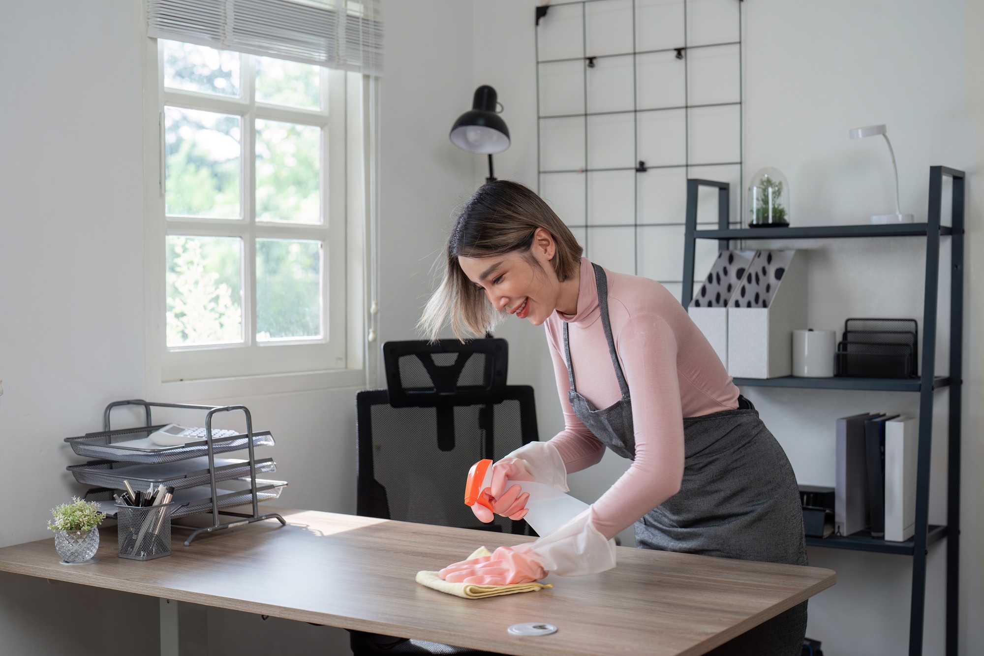 Professional Maid Cleaning Modern Home Office with Natural Light and Organized Workspace