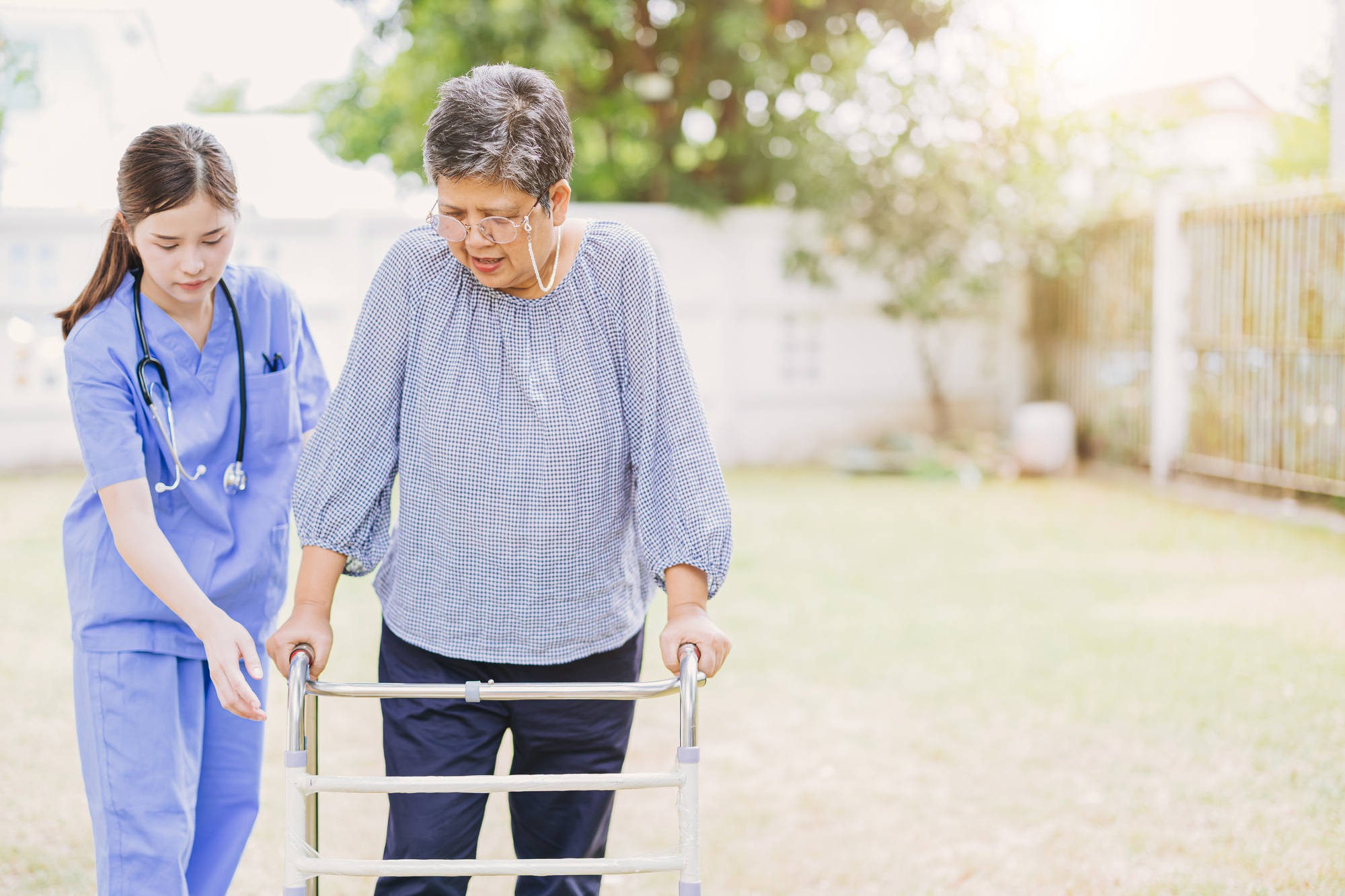 senior elderly adult woman with disability using walker walk practice in home care nurse doctor